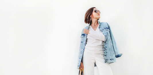 Woman in white outfit with denim jacket over her shoulder